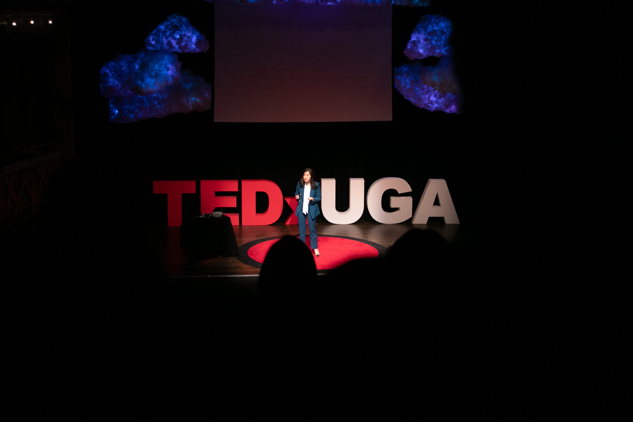 TEDxUGA presenter on stage with crowd in foreground